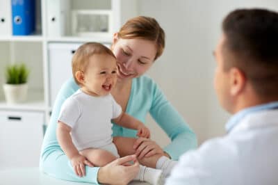 A toddler and his mother meeting a doctor.